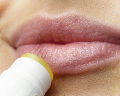femme qui utilise un baume à lèvres au CBD