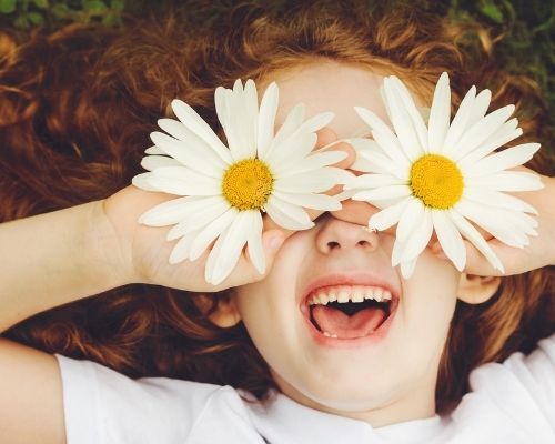 Enfant avec des fleurs sur le visage